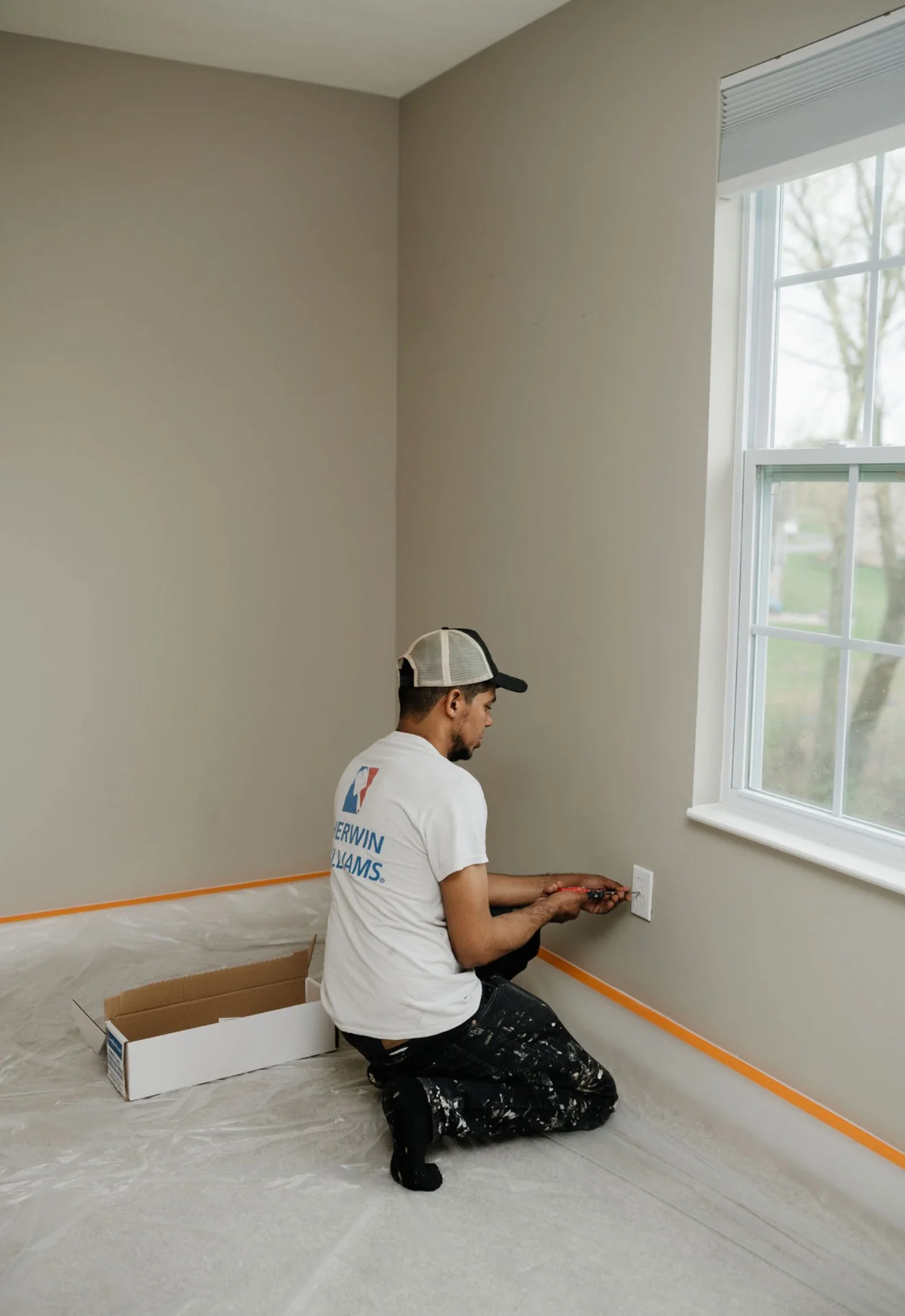 Professional painter applying interior paint to residential wall