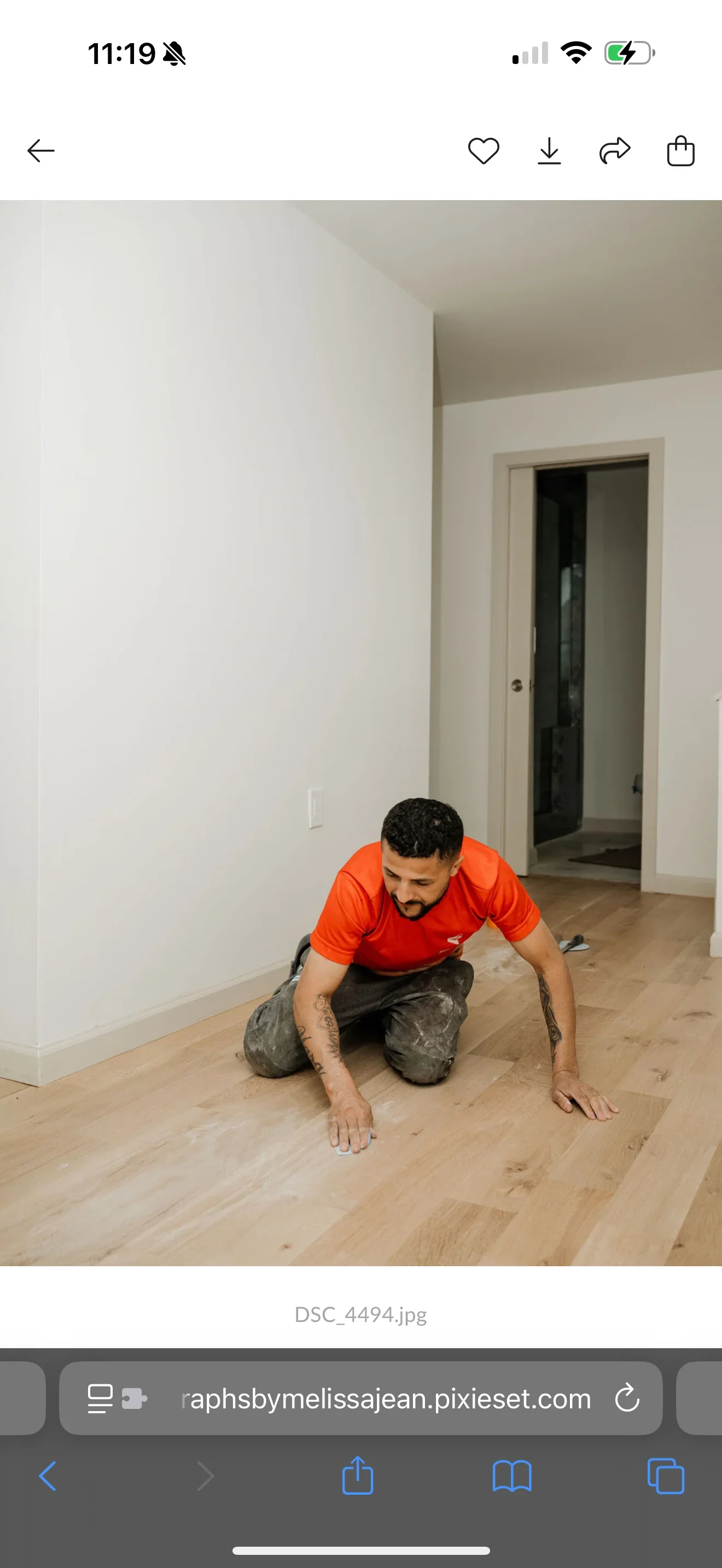 Interior room with white painted walls, trim, and new light wood laminate flooring installation