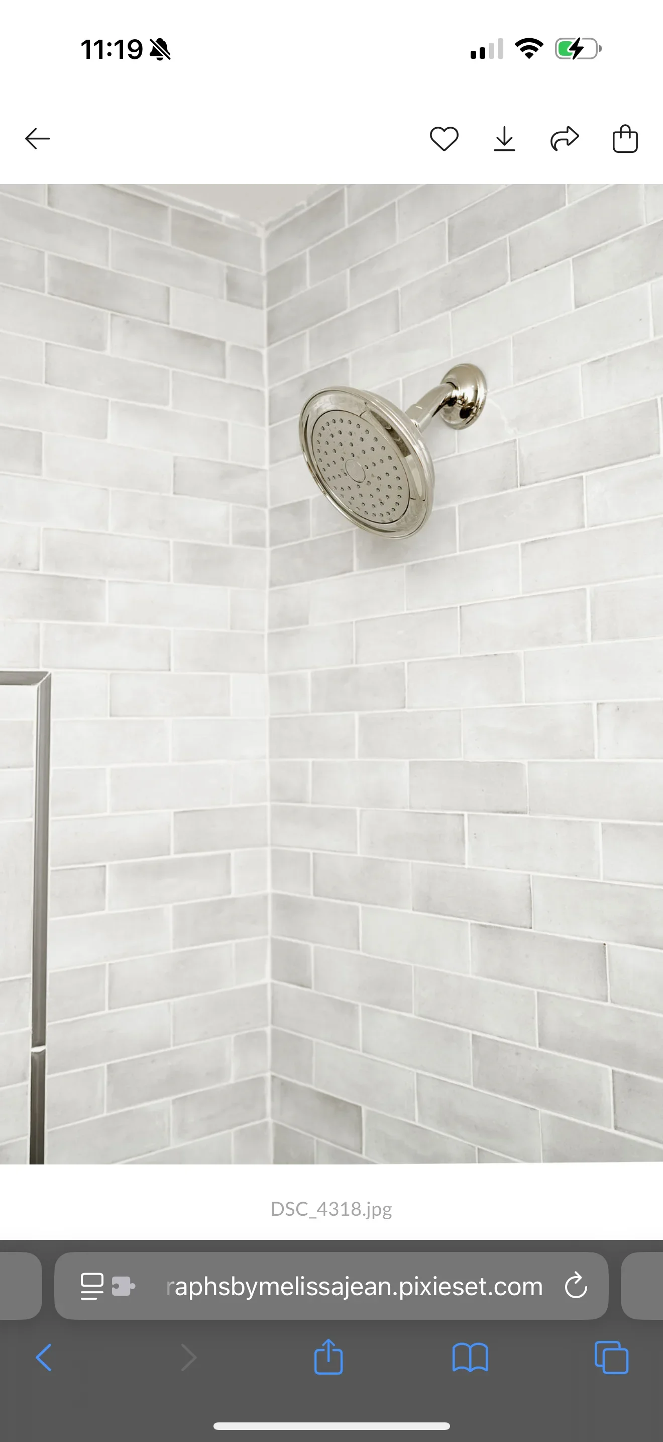 White subway tile shower with polished nickel showerhead and wall-mounted arm